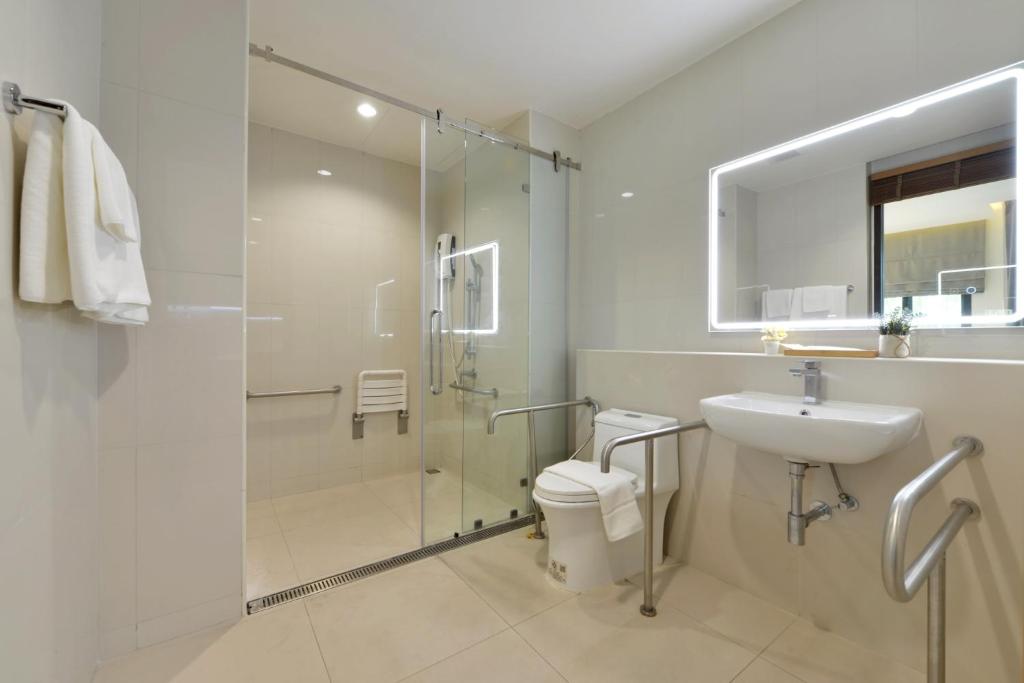 A bright accessible bathroom with a glass-enclosed shower.