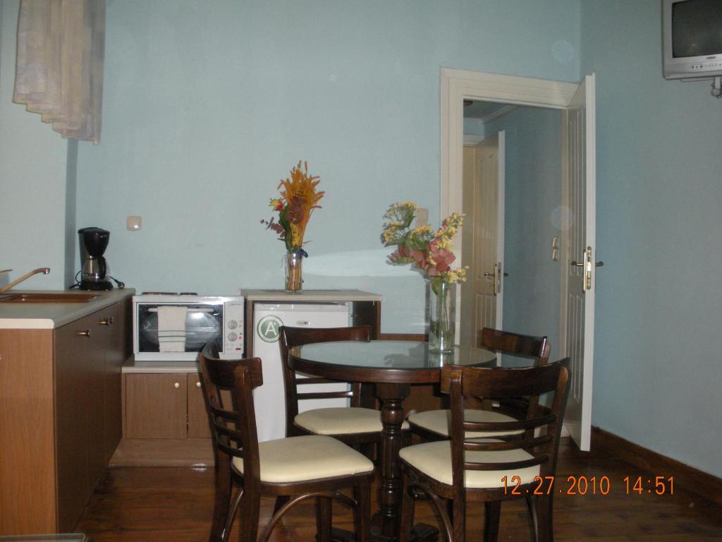 eine Küche mit einem Tisch und Stühlen in der Unterkunft En Ermoupoli in Ermoupoli