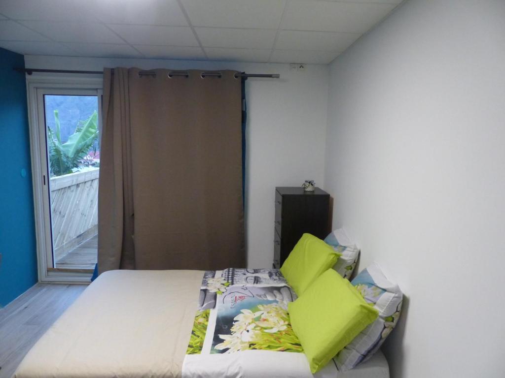 1 dormitorio con 1 cama con almohadas de color verde lima en Le Bas de Cilaos, en Cilaos