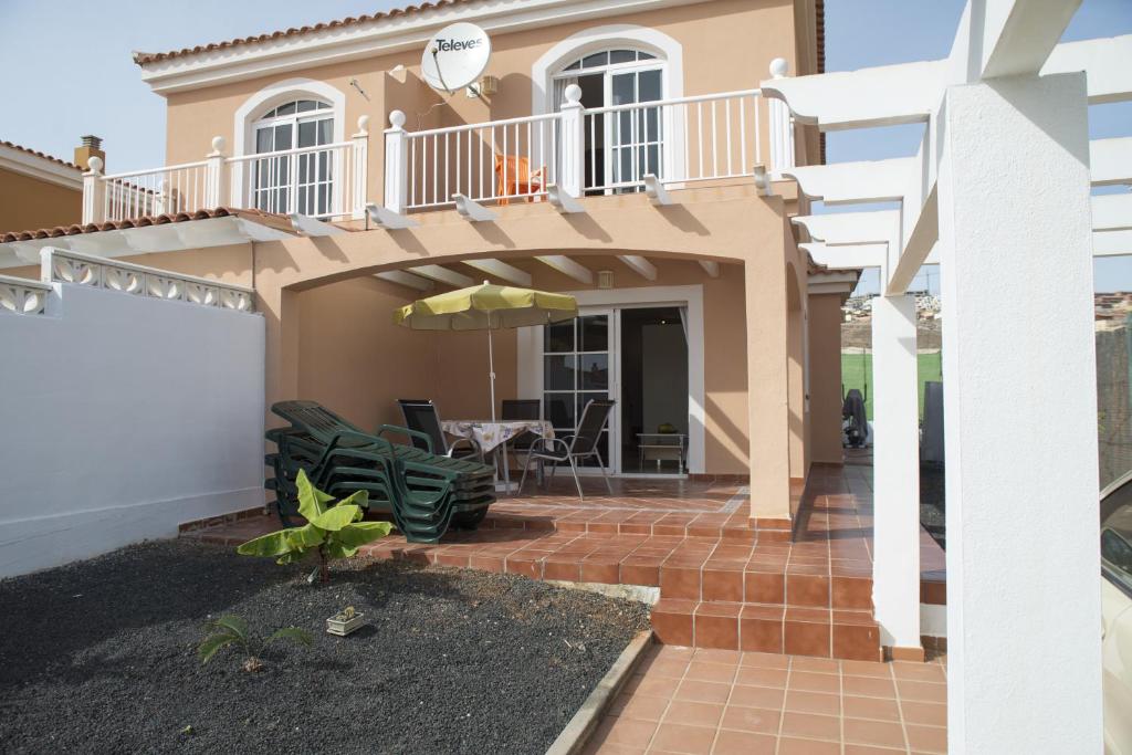 a house with a patio and a balcony at Casa Playa in Caleta De Fuste