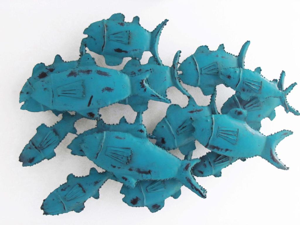 B&B Caorle For You في كاورلي: مجموعة من تماثيل الأسماك الزرقاء على خلفية بيضاء