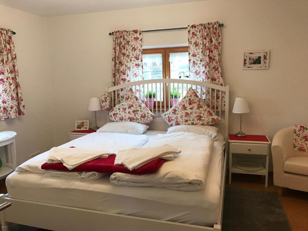 Schlafzimmer mit einem weißen Bett und roten Vorhängen in der Unterkunft Ferienwohnung Magdalena - ruhig, zentral, schöne Sonnenterrasse in Schliersee