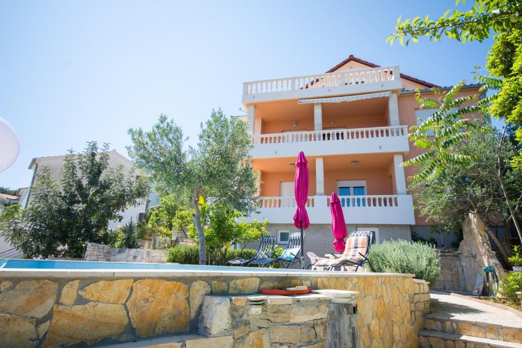 トロギールにあるApartmani Cubelaの正面にプールがある家