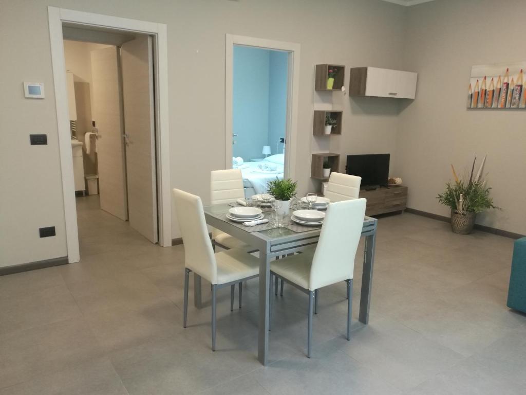 Lingotto Residence في تورينو: غرفة طعام مع طاولة وكراسي بيضاء