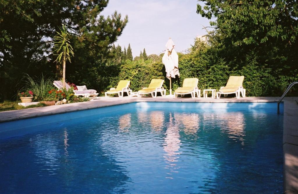 ein Pool mit Stühlen und eine Statue daneben in der Unterkunft Gîte Saint-Veredeme in Pujaut