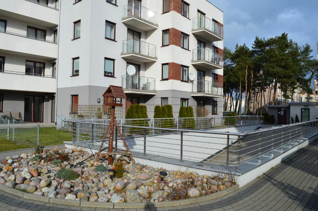 a building with a garden in front of a building at Family Homes - Apartamenty Bursztynowe in Władysławowo