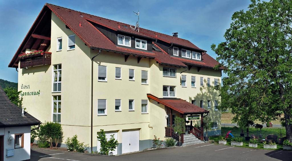 a large white building with a red roof at Ferienwohnungen Tannenhof in Steinen