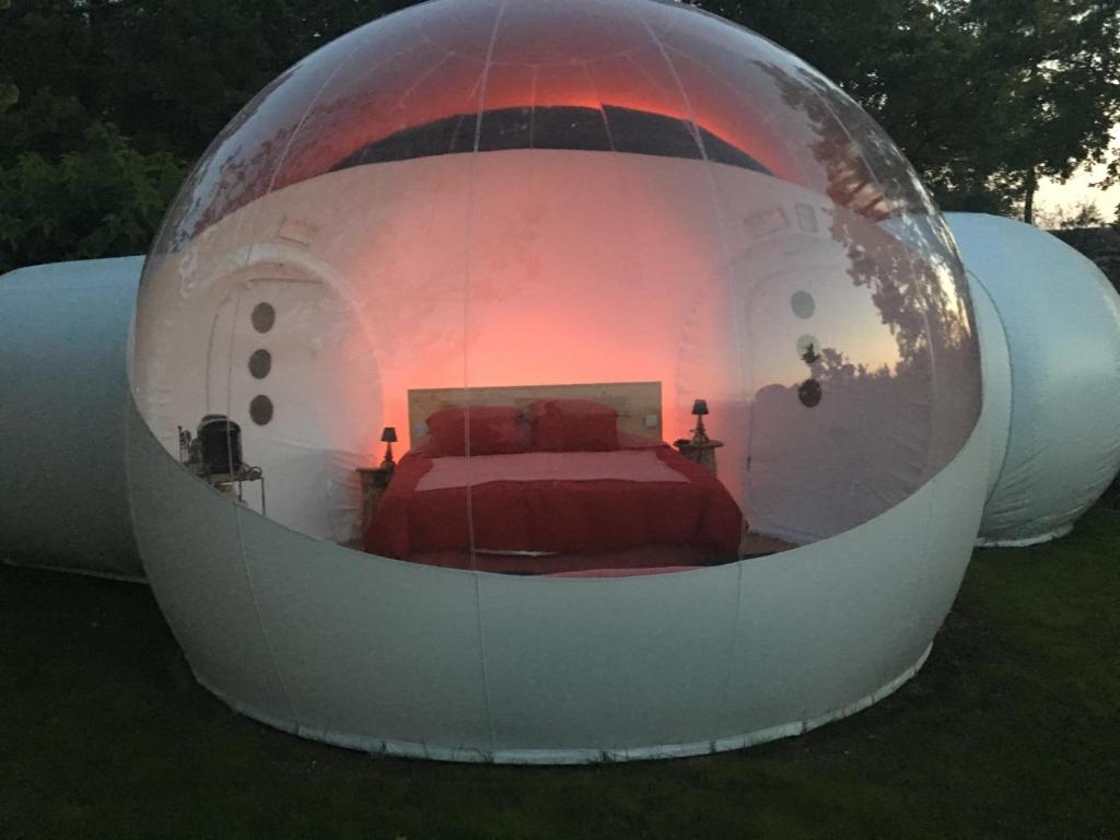 Una cama dentro de una cúpula blanca con una cama dentro en Bulle d'amour, en Montauroux