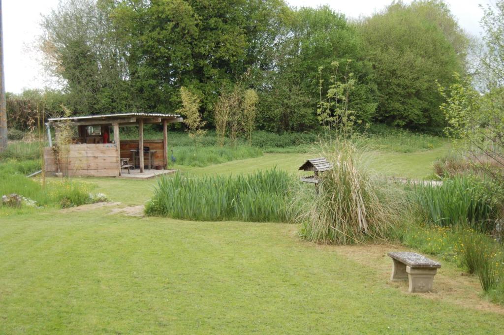 a park with a bench and a shelter in the grass at Lac de la Vie in Bressuire