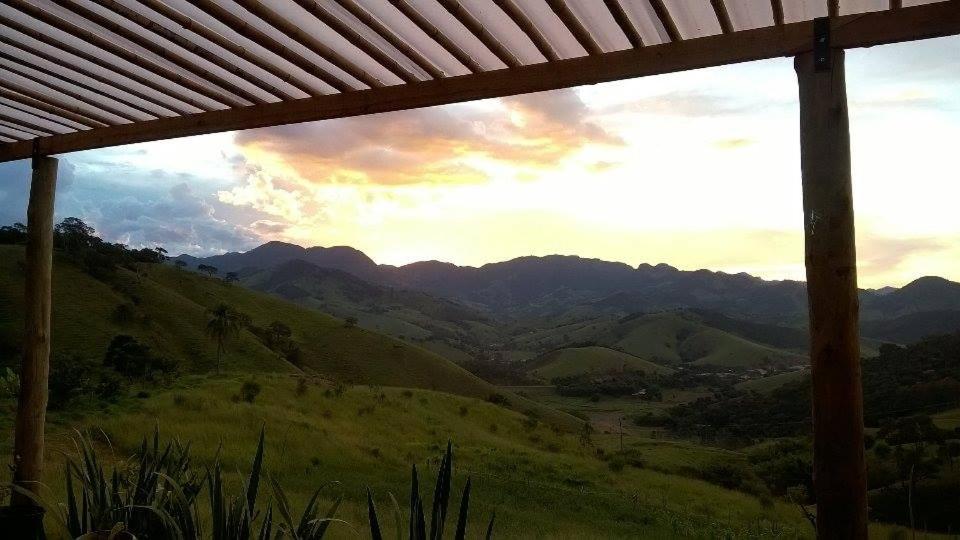 a view of a mountain range from a window at Reobote Chalés in São Bento do Sapucaí