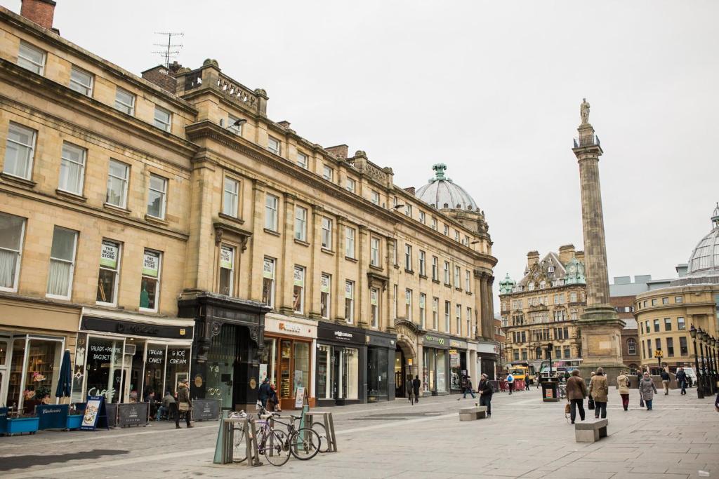 a city street with buildings and people walking around at 93a Grey Street Apartments in Newcastle upon Tyne