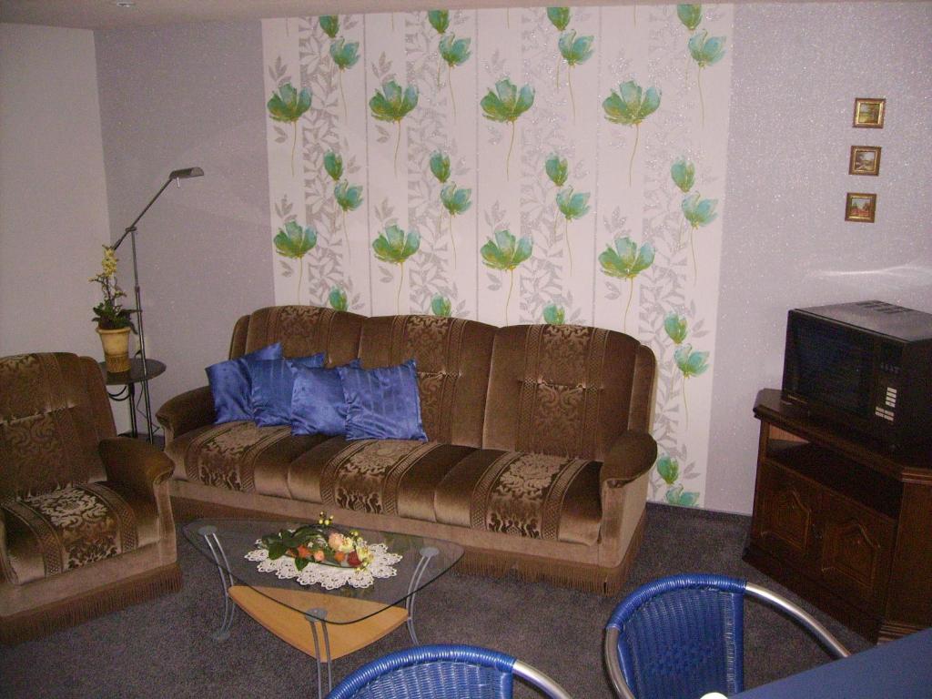 ein Wohnzimmer mit einem Sofa und einem Tisch in der Unterkunft Ferienwohnung Fröhlich in Bad Suderode