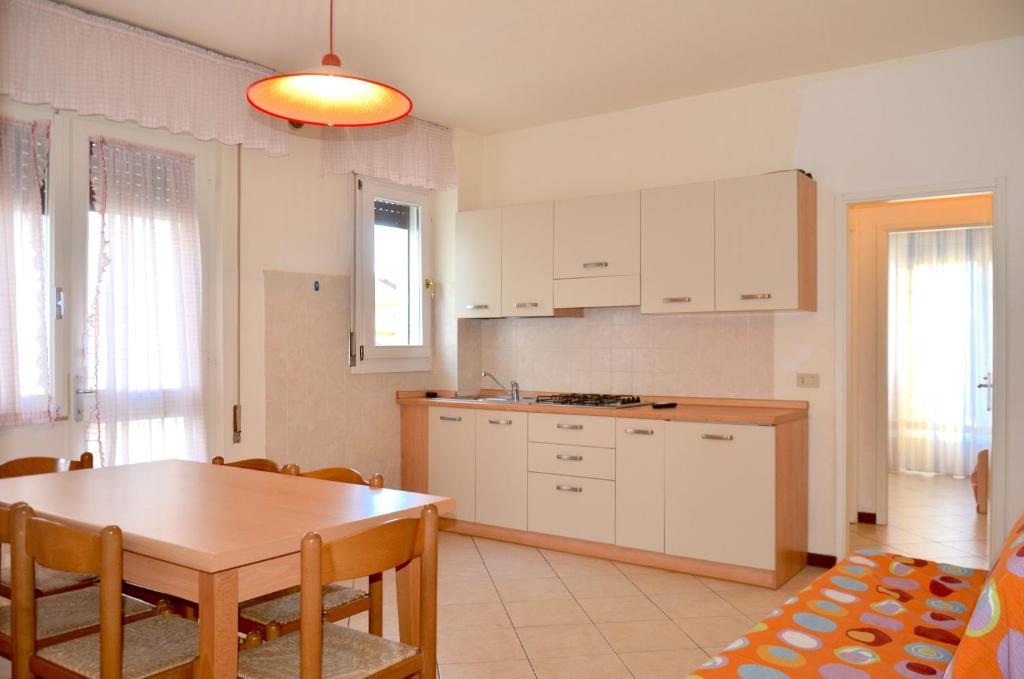 a kitchen with a table and a dining room at Villa Carlotta in Lignano Sabbiadoro
