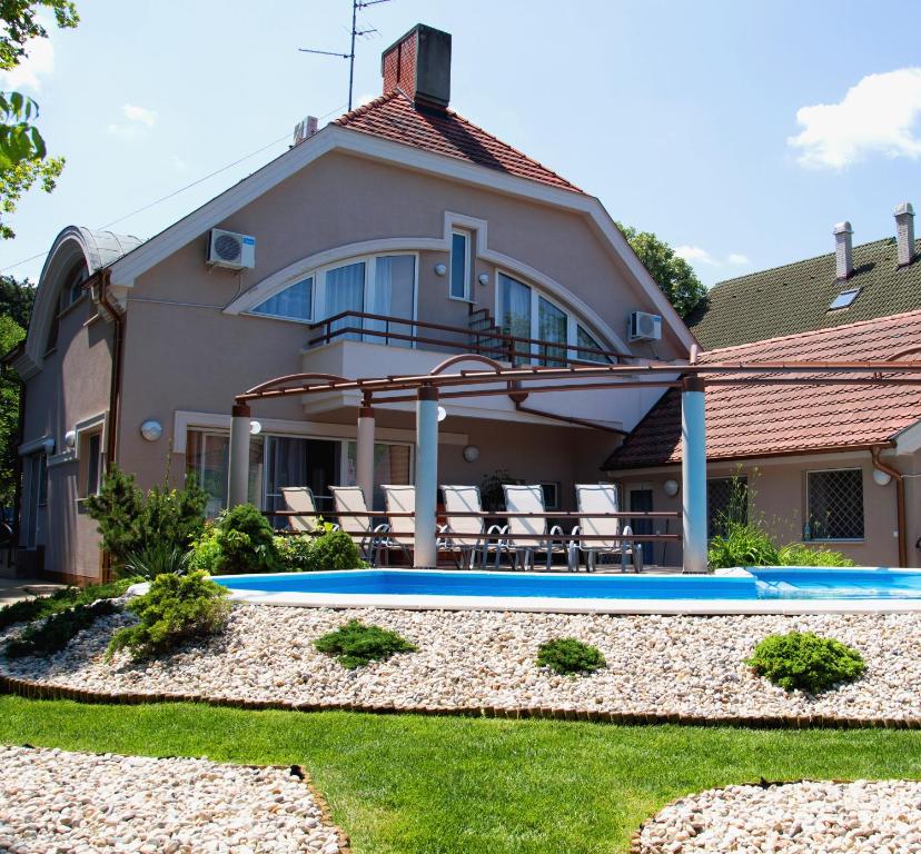una casa con piscina frente a ella en Princess Apartman, en Siófok