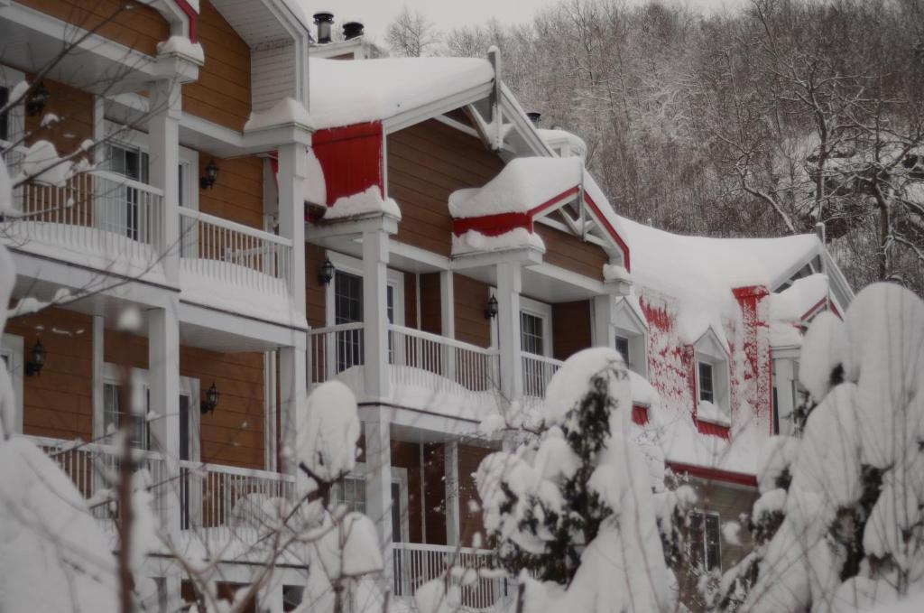 a house covered in snow at Auberge du Lac Morency in Saint-Hippolyte