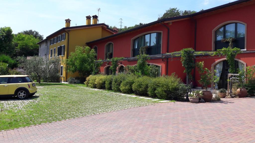 a red house with a car parked in front of it at Agriturismo Camparella in Pastrengo