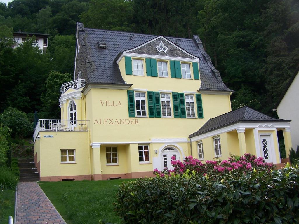 Ein gelbes Haus mit einem Schild, das die Villa Allegorie liest in der Unterkunft Ferienwohnung "Villa Alexander" 4 DTV-Sternen Neu Eröffnung in Bad Ems