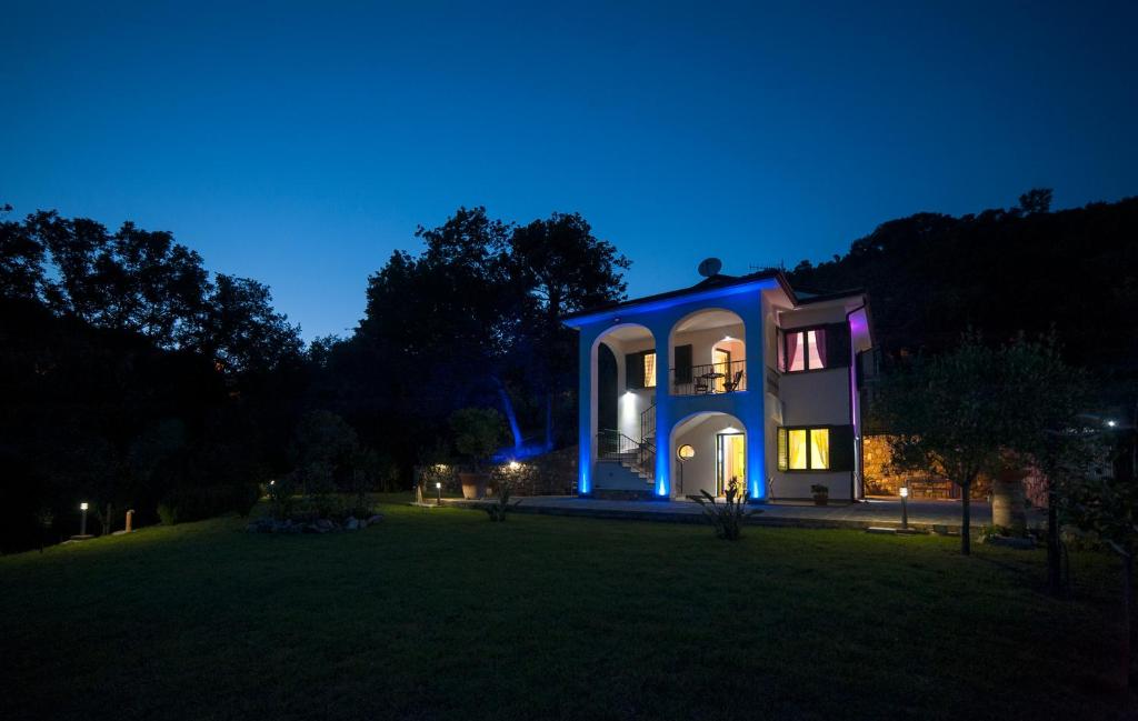 une maison avec des lumières bleues sur une cour la nuit dans l'établissement Incanto di Luna, à Ispani