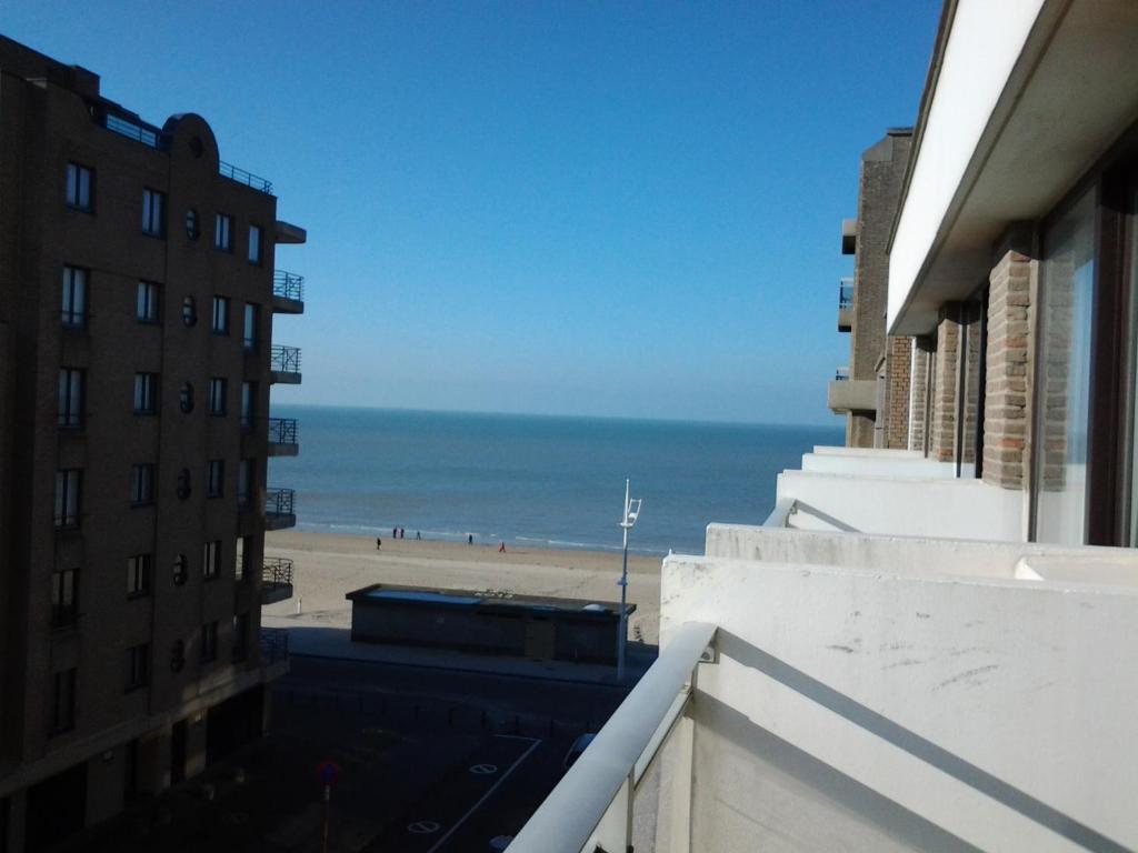 Blick auf den Strand vom Balkon eines Gebäudes in der Unterkunft Zonnig Appartement met Zeezicht in Koksijde
