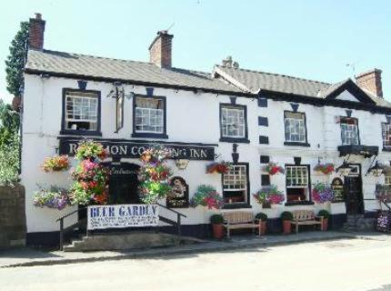 a white building with flowers in front of it at Red Lion Coaching Inn in Ellesmere
