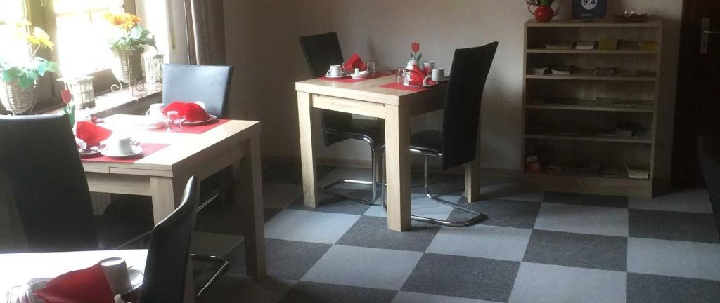 una habitación con una mesa y sillas con sombreros rojos. en Pension Ulrich en Dahlem