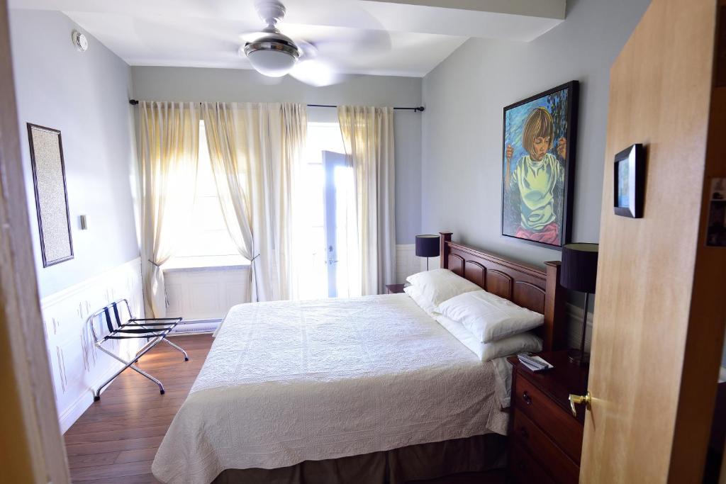 a bedroom with a large bed and a window at Auberge le St-Georges in Saguenay
