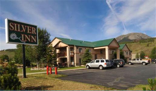 a hotel with cars parked in a parking lot at Silver Inn in Silverthorne