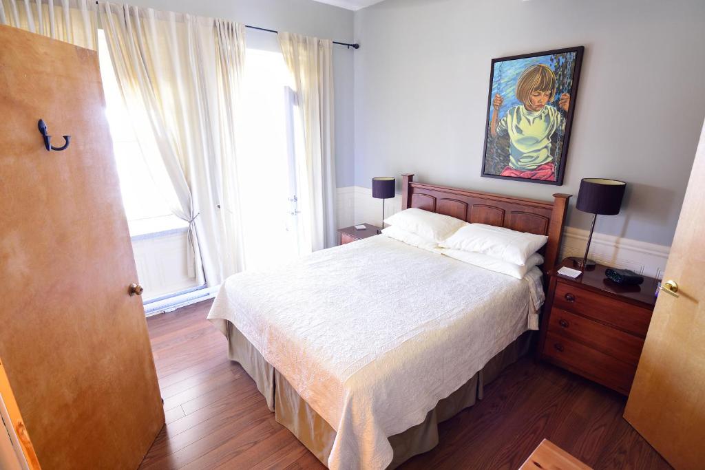 a bedroom with a bed and a painting on the wall at Auberge le St-Georges in Saguenay