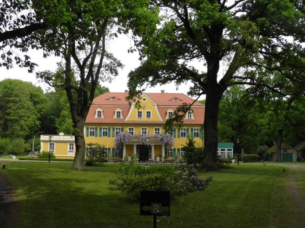 Lohsa的住宿－Fledermausschloss，草坪上一座黄色房子,屋顶红色