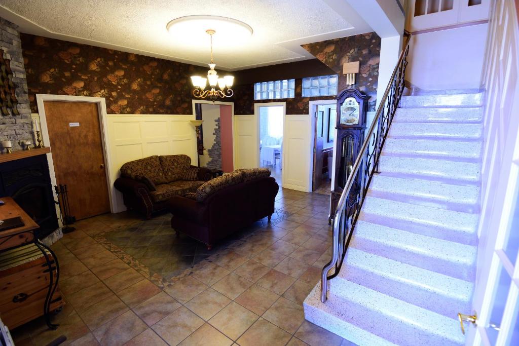 a living room with a staircase and a couch at Auberge le St-Georges in Saguenay