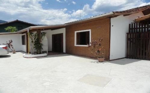 a house with a large patio in front of it at Pousada Edson in Caraguatatuba