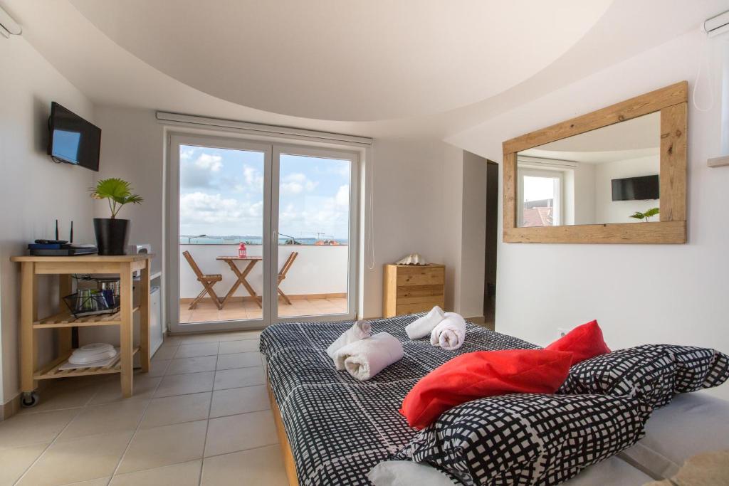a bedroom with a bed with pillows and a mirror at Alex Surf Hostel in Baleal