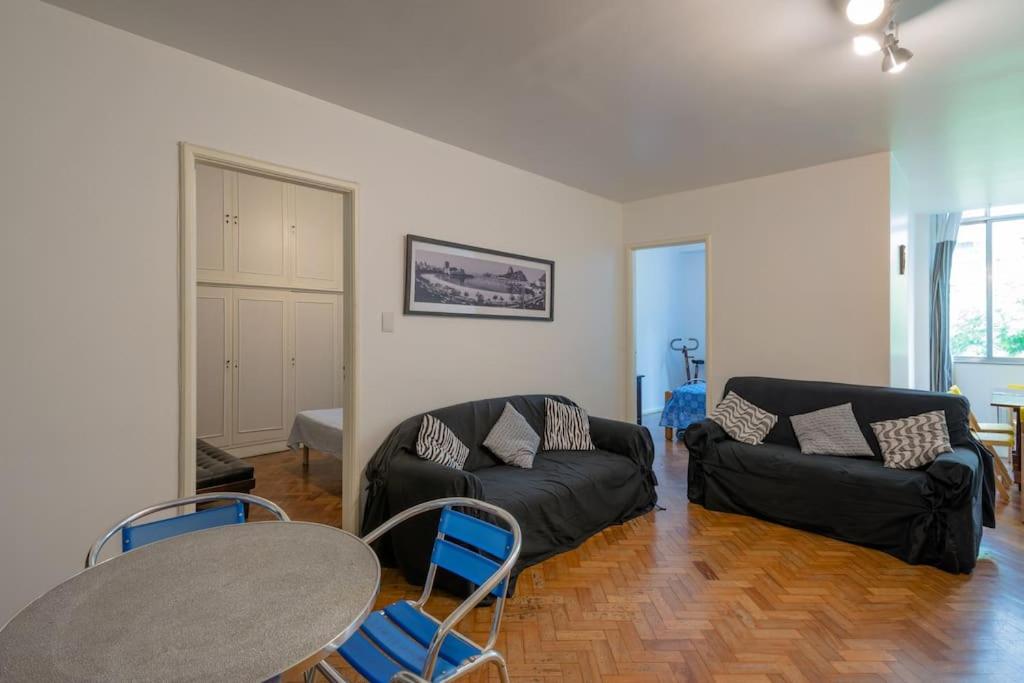 sala de estar con sofá negro y mesa en Apartamento de 3 quartos prox ao Posto 2 - COPACABANA, en Río de Janeiro