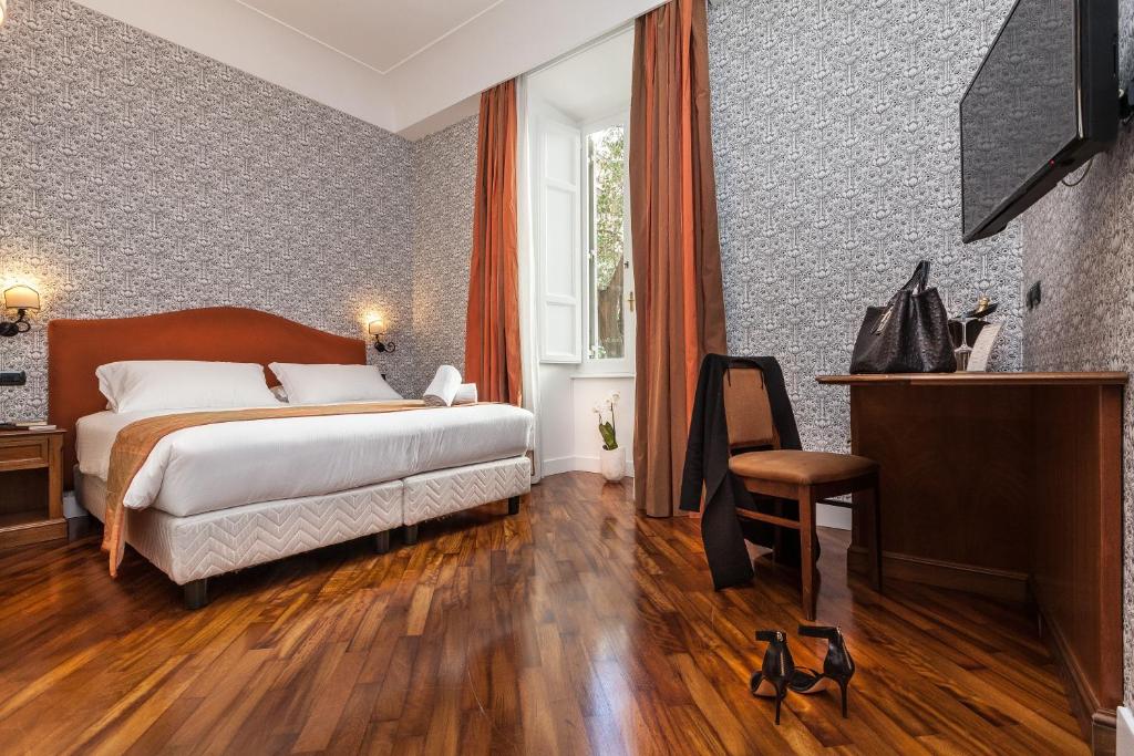 a hotel room with a bed and a television at Suite Beccaria A Piazza Del Popolo in Rome