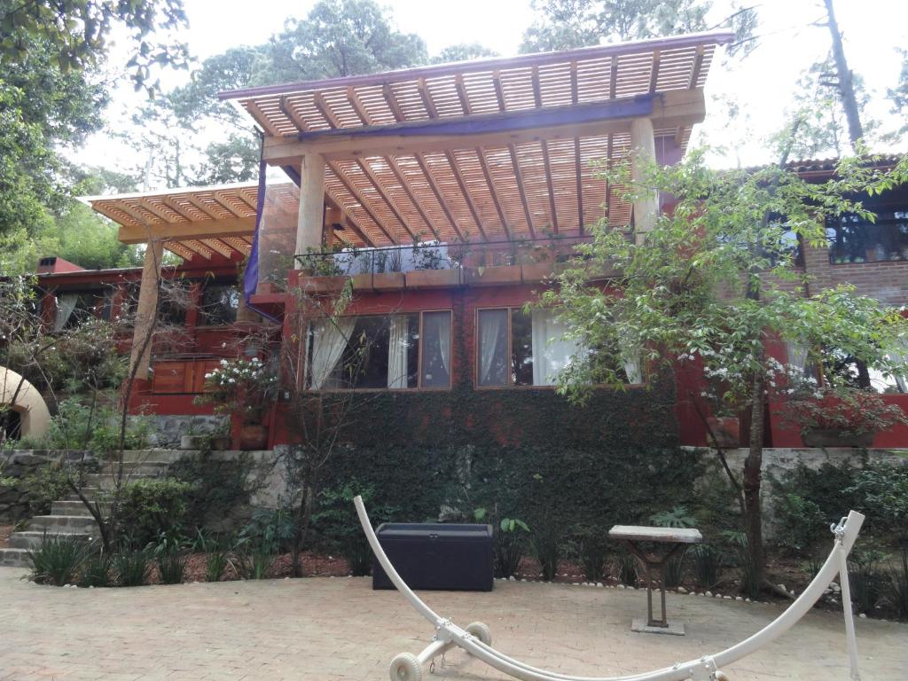 una casa con techo de madera y valla en La Casa del Rio, en Valle de Bravo