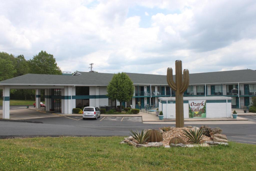 a hotel with a cactus in front of a building at Ozark Valley Inn in Branson
