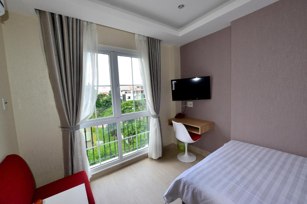 a hotel room with a bed and a window at Phu My Hung - Saigon South Serviced Apartments - Near Vivo City Mall in Ho Chi Minh City