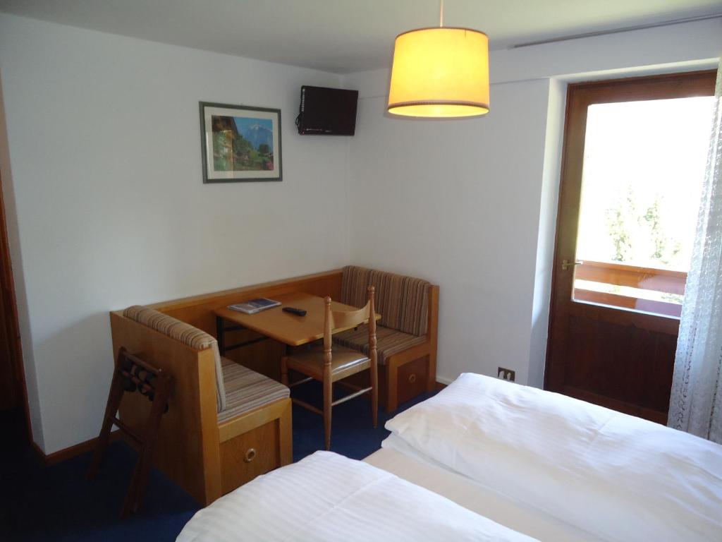 A bed or beds in a room at Hotel Pensione Dolomiti