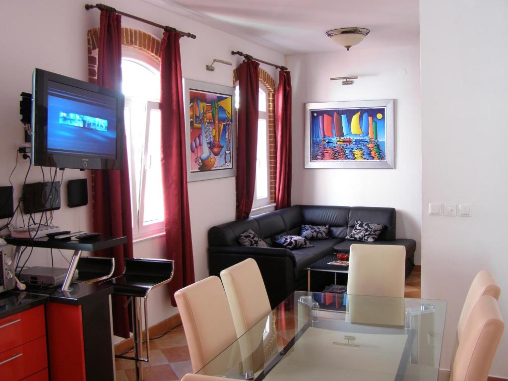 ein Wohnzimmer mit einem Glastisch und einem TV in der Unterkunft Split Artistic Apartments in Split