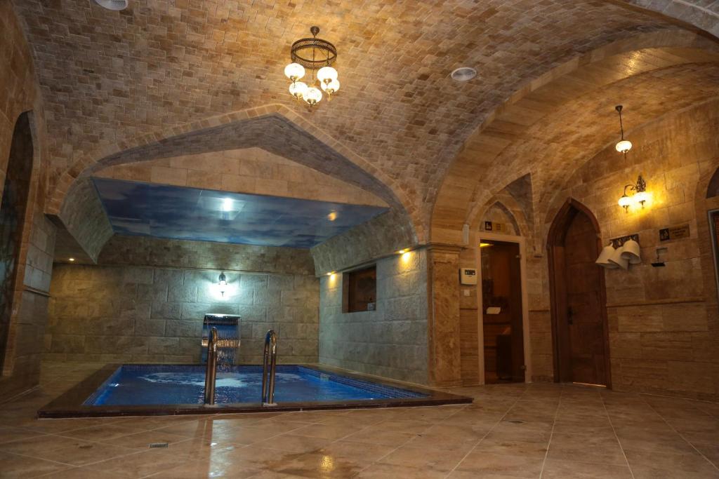 a large swimming pool in a room with a stone wall at Royal Hotel in Baku