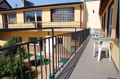 a balcony of a house with a table and chairs at Pokoje Gościnne Wanda in Władysławowo