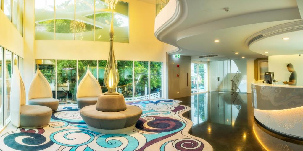 A colourful double-height lobby lounge combines sculptural seating with a curved reception desk.