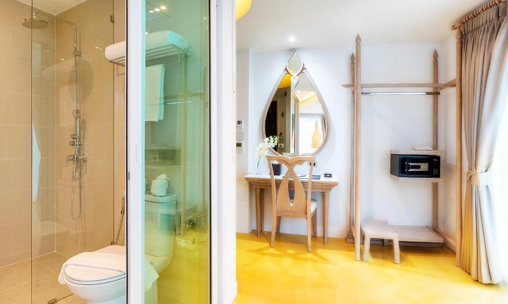 A compact bathroom with a glass-enclosed shower beside a dressing area.