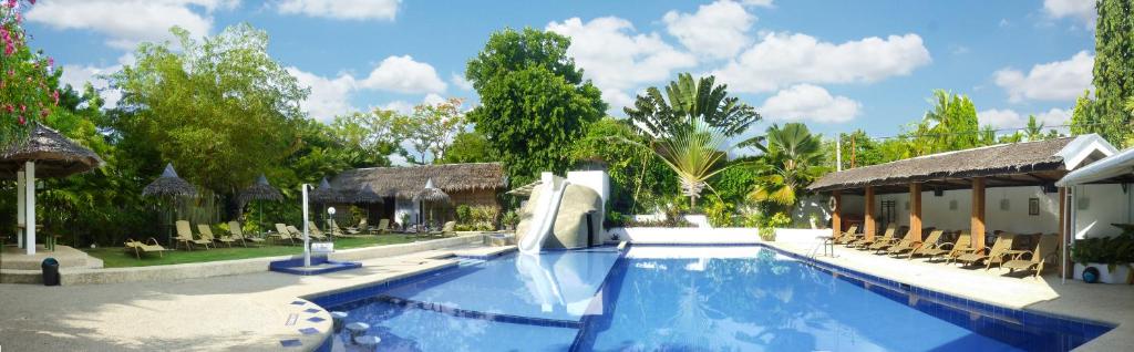 a pool with a water slide in a resort at Marcosas Cottages Resort in Moalboal