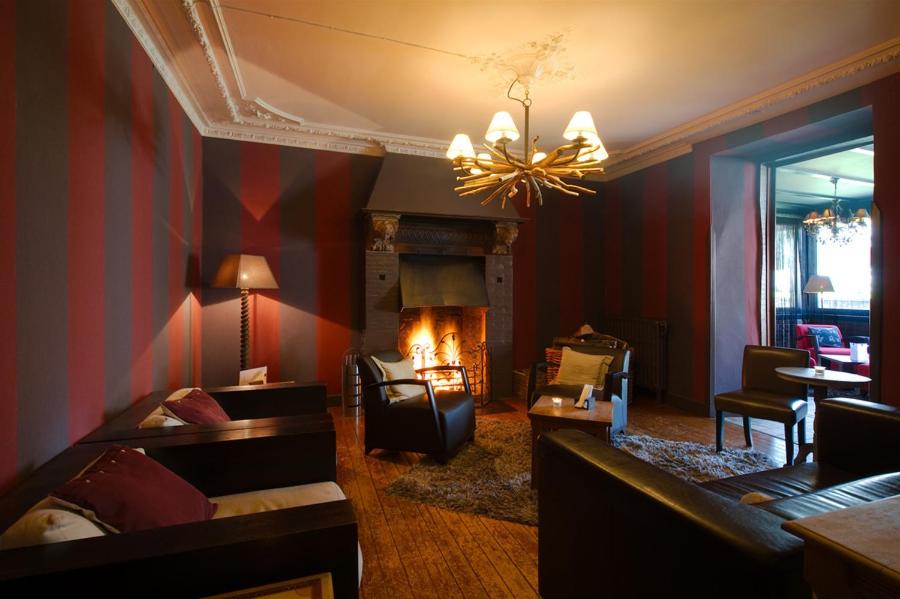 sala de estar con sofá y chimenea en Hotel Le Beau Séjour en Nassogne