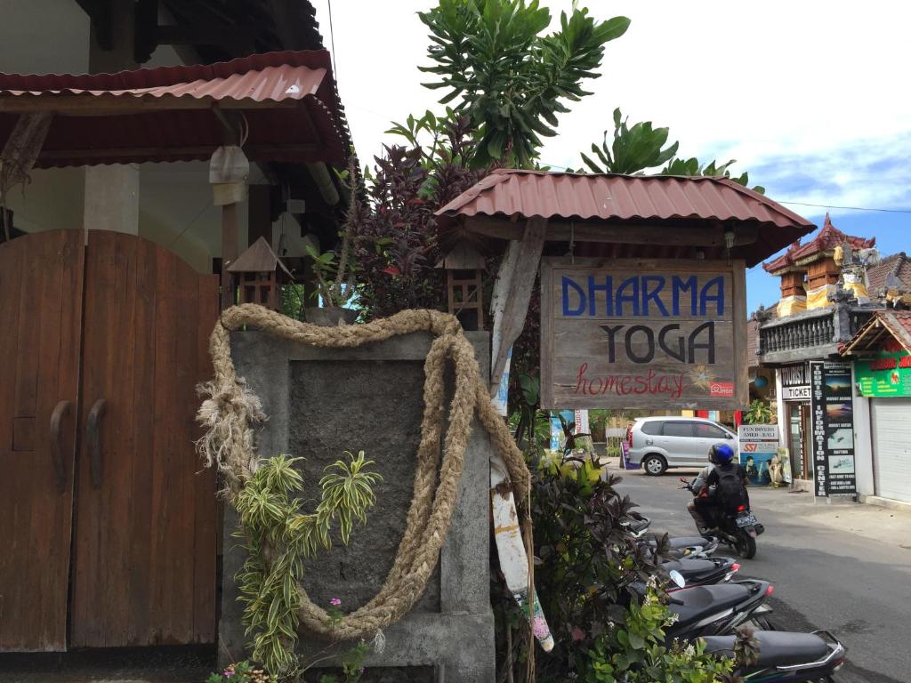 un bâtiment avec un panneau sur le côté d'une rue dans l'établissement Dharma Yoga Homestay dan hostel, à Amed