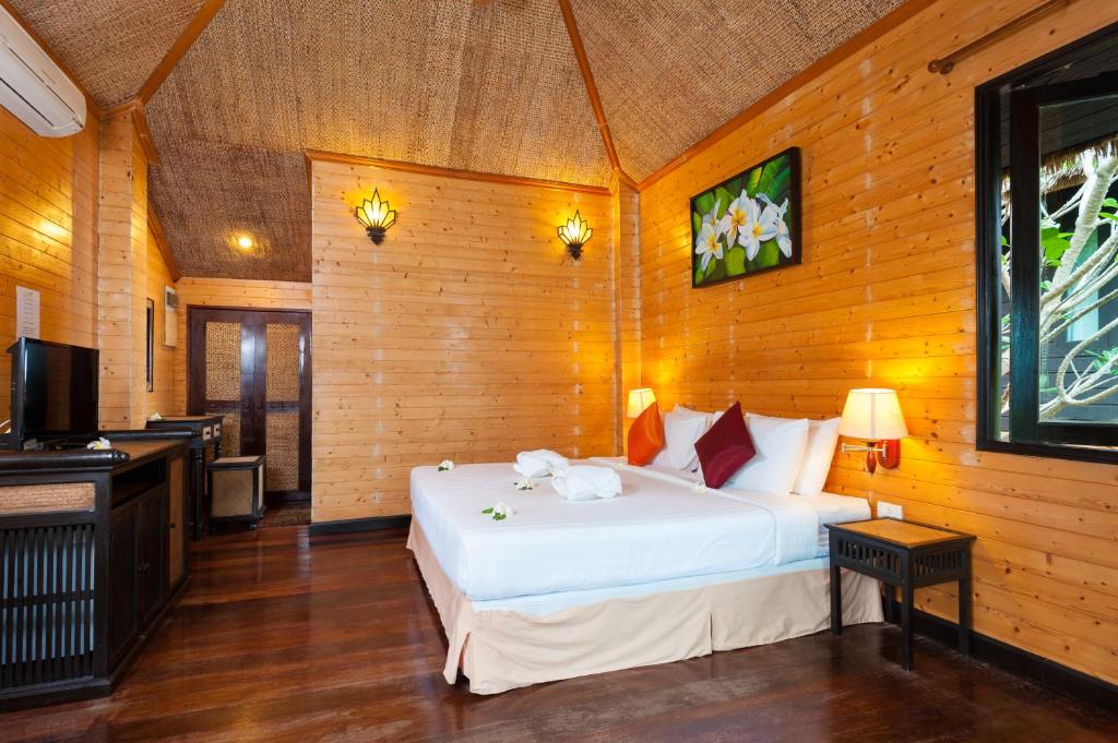 a bedroom with a white bed and a television at Palm Leaf Resort Koh Tao in Ko Tao