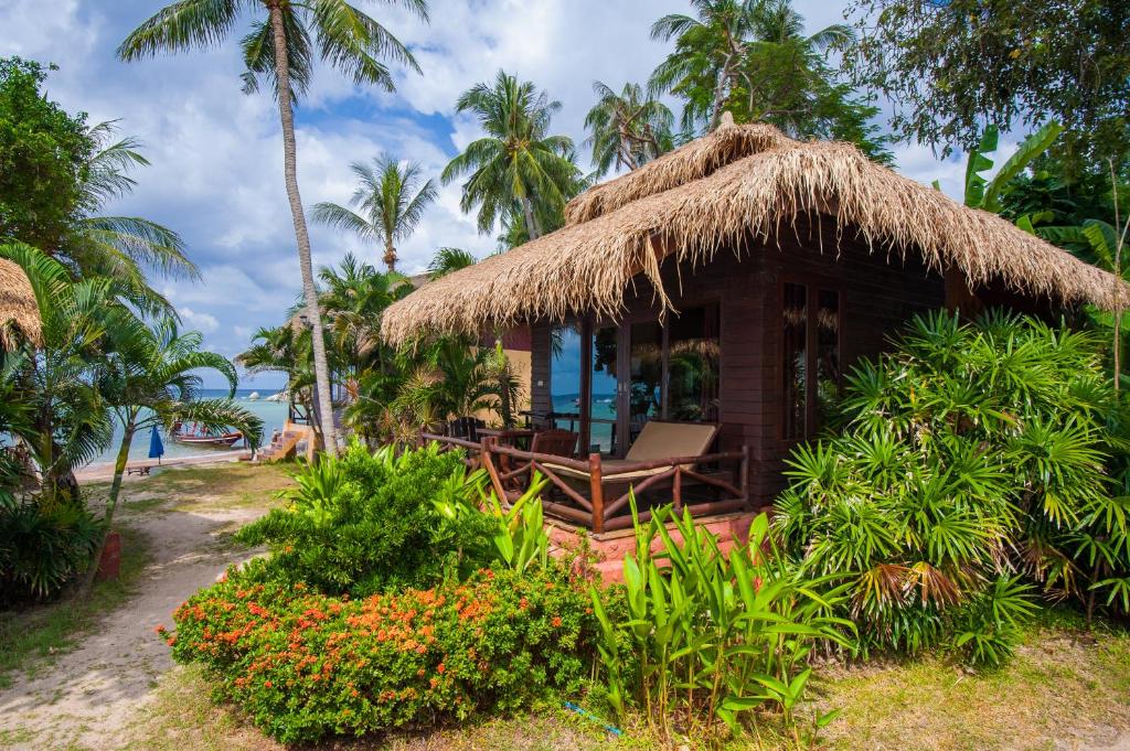 a small hut with a straw roof on the beach at Palm Leaf Resort Koh Tao in Ko Tao