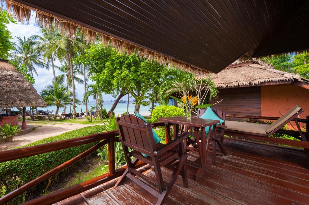 a wooden deck with a table and chairs on it at Palm Leaf Resort Koh Tao in Ko Tao