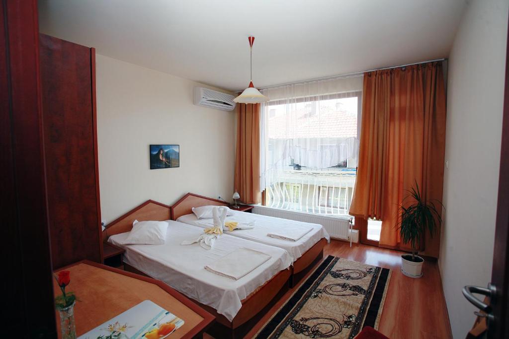 a bedroom with a bed and a large window at Family Hotel Denica in Obzor